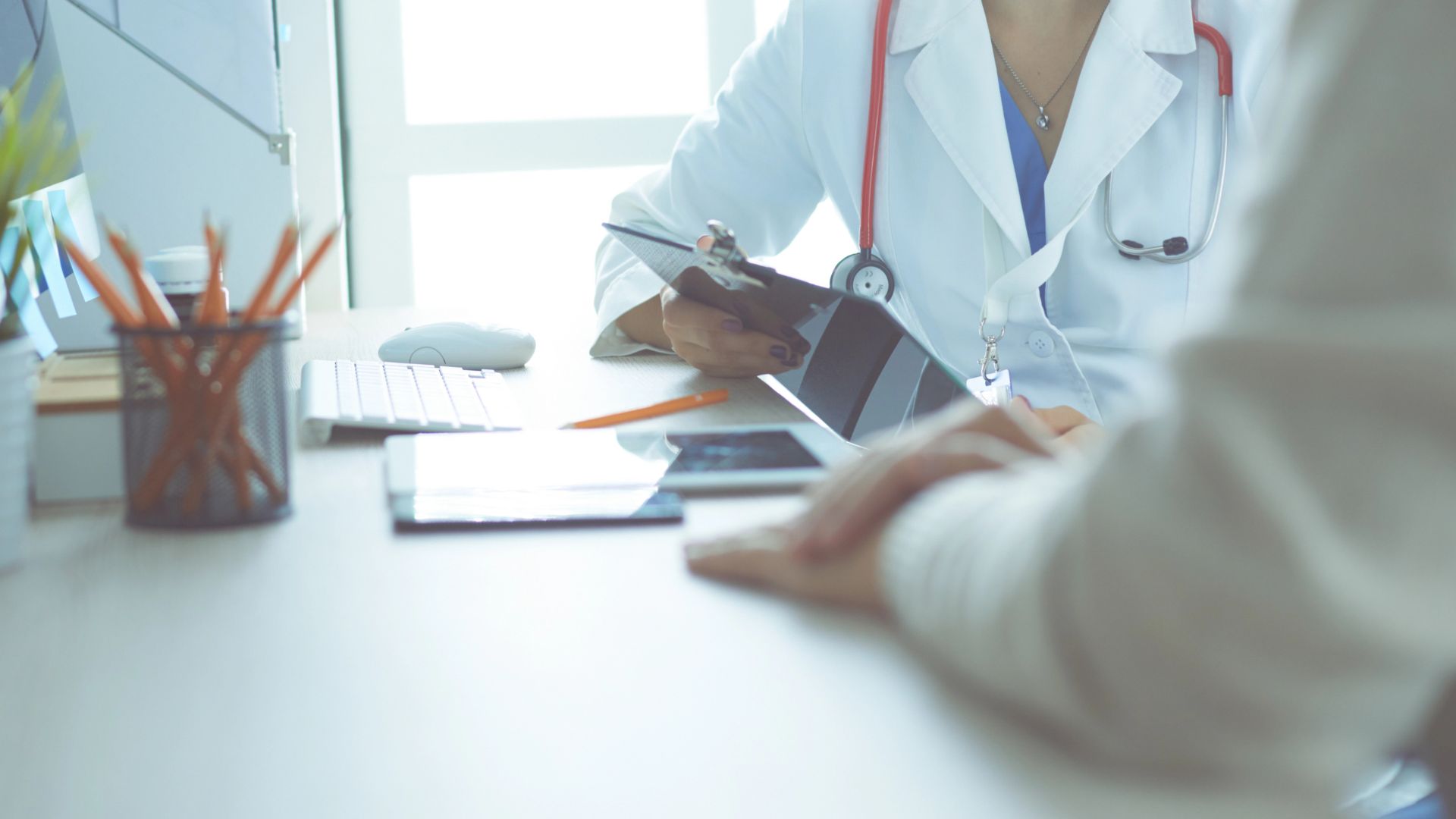 A doctor is talking and examining a patient