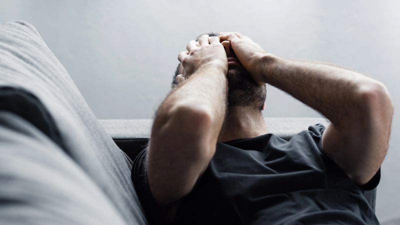 Depressed man lying on sofa