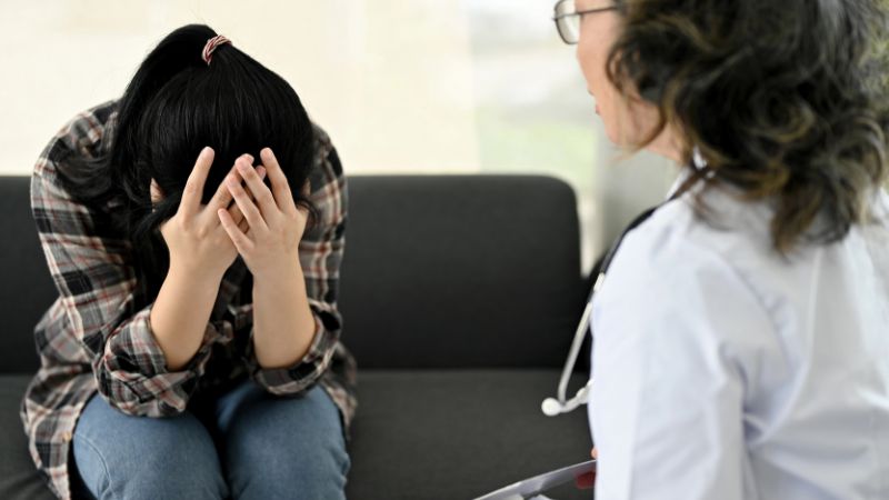 depressed young woman having an appointment with her personal psychiatrist