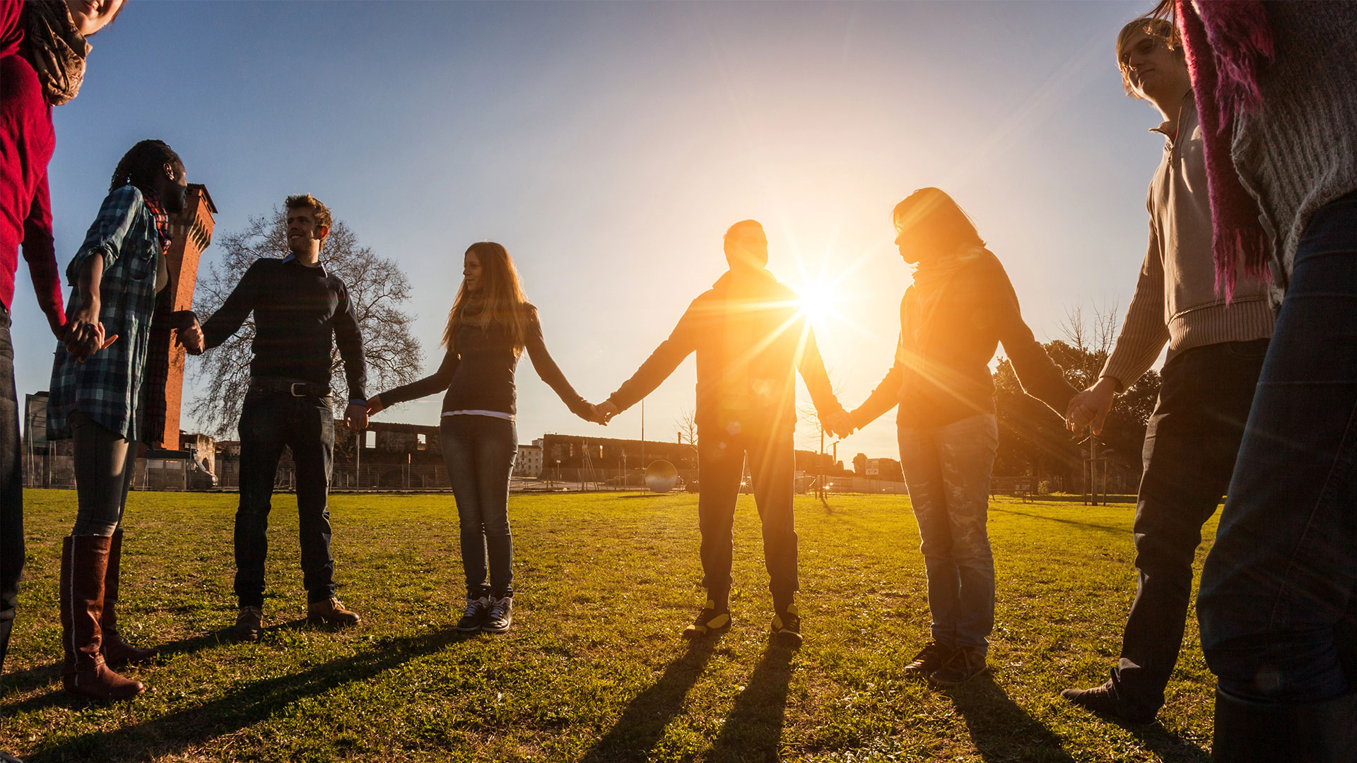 support group holding hands in an open field