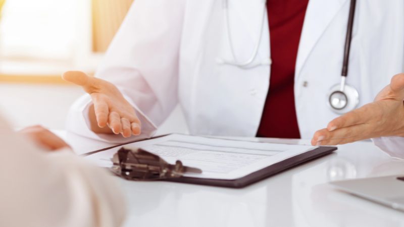 doctor and patient discussing something while sitting at the table