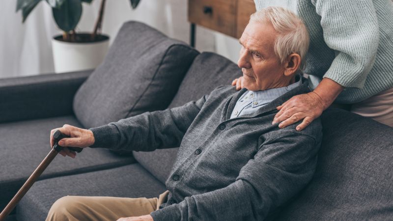 senior wife hugging retired husband at home