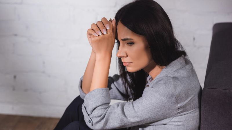 Stressed woman holding clenched hands