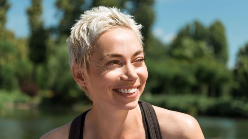 beautiful smiling woman looking away in park
