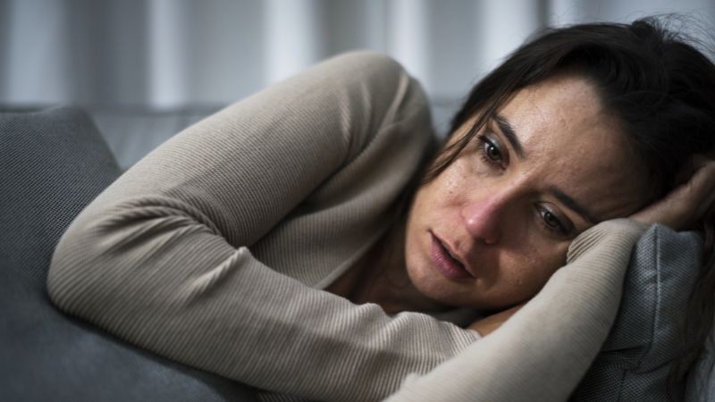 Depressed woman lying on bed