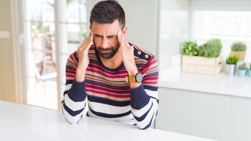 man at home suffering from headache