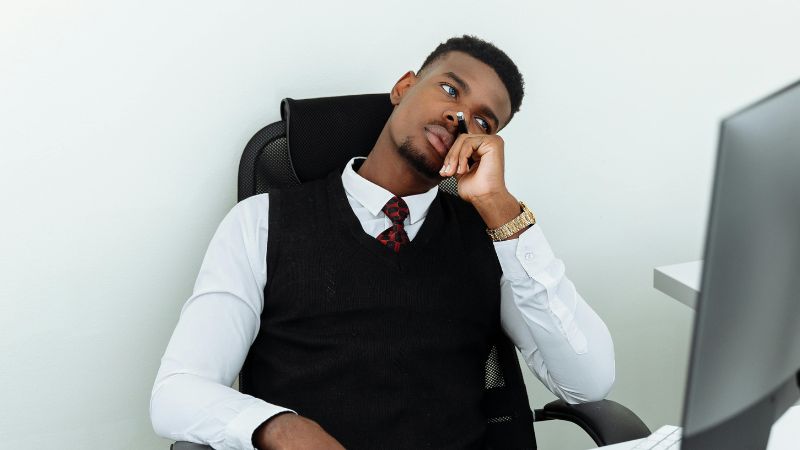 Man in Black Vest and White Dress Shirt Sitting on Black Chair