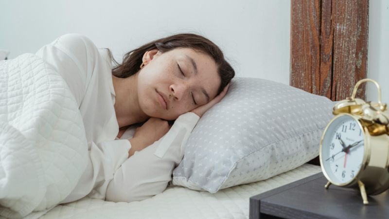 Calm woman sleeping on pillow in bedroom