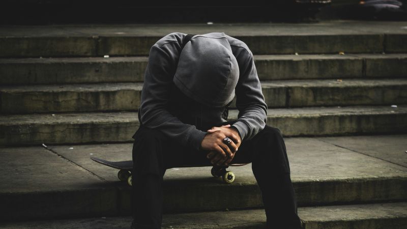 a man sitting on some steps with his head in his hands