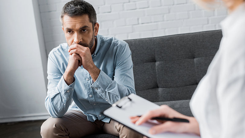 Depressed adult man on therapy session