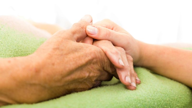Nurse holding woman hand