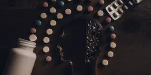 Common mental health tablets and pills arranged around the outline of a human head.