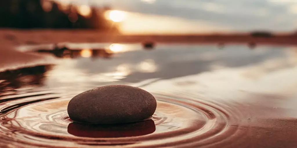 A smooth stone in calm water, finding peace when you feel anxious for no reason.