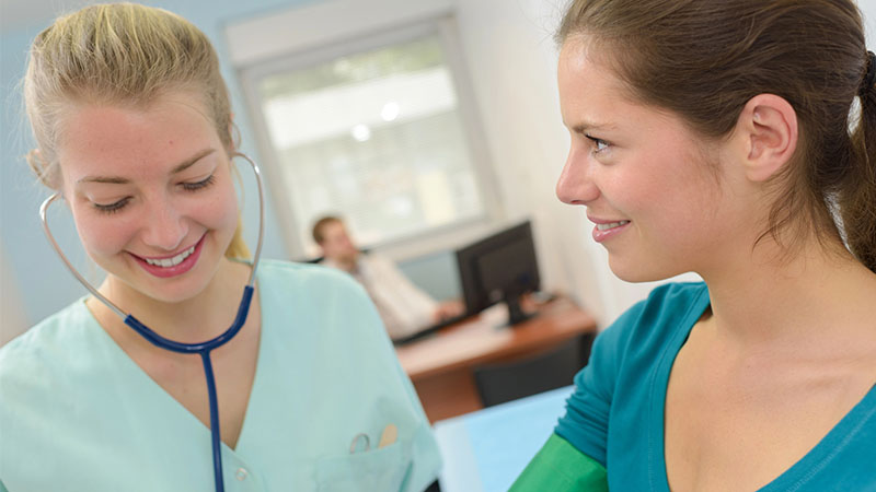 female nurse checking blood pressure