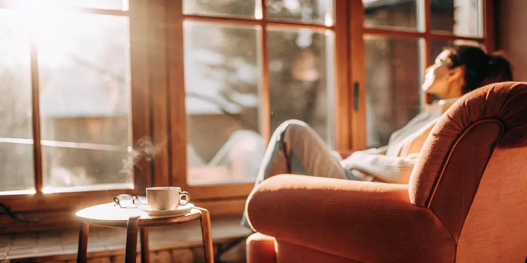 A woman relaxes with coffee while learning how to find a TMS provider for OCD.