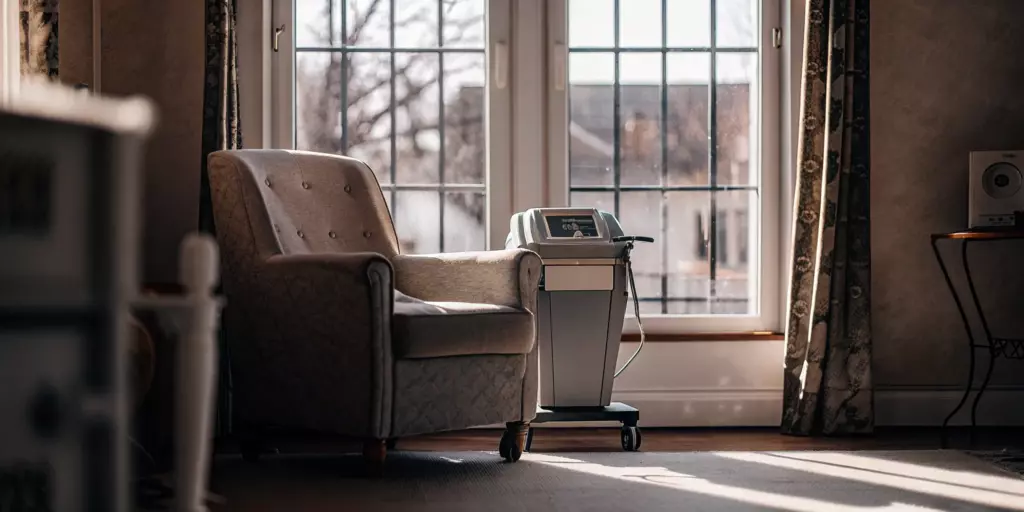 A TMS therapy machine in a treatment room, comparing if TMS is the same as ECT.