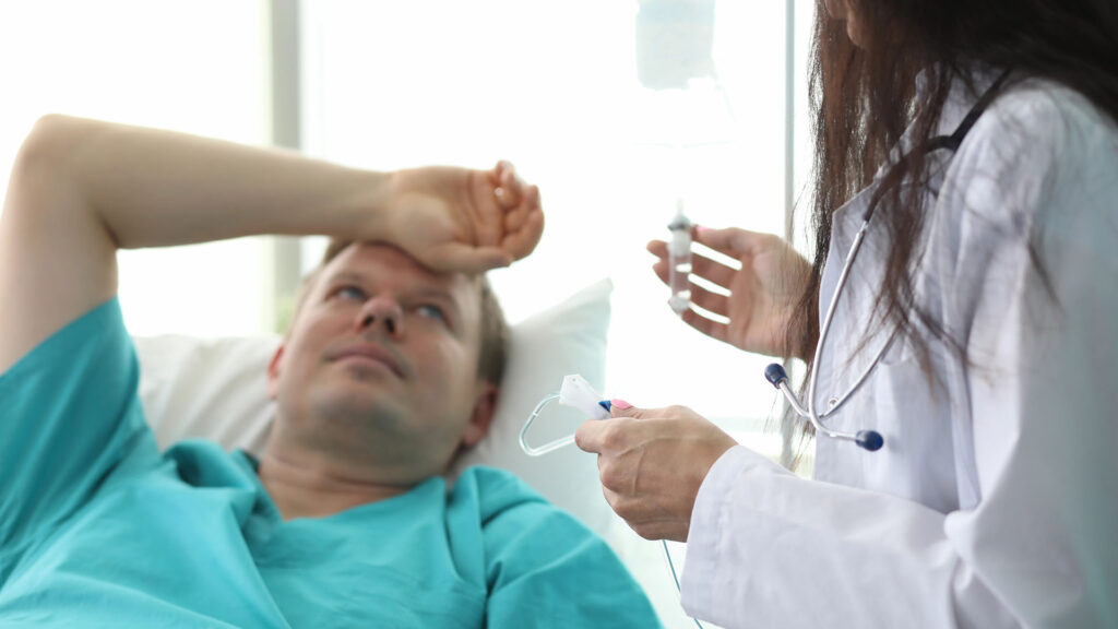 male patient holding forehead