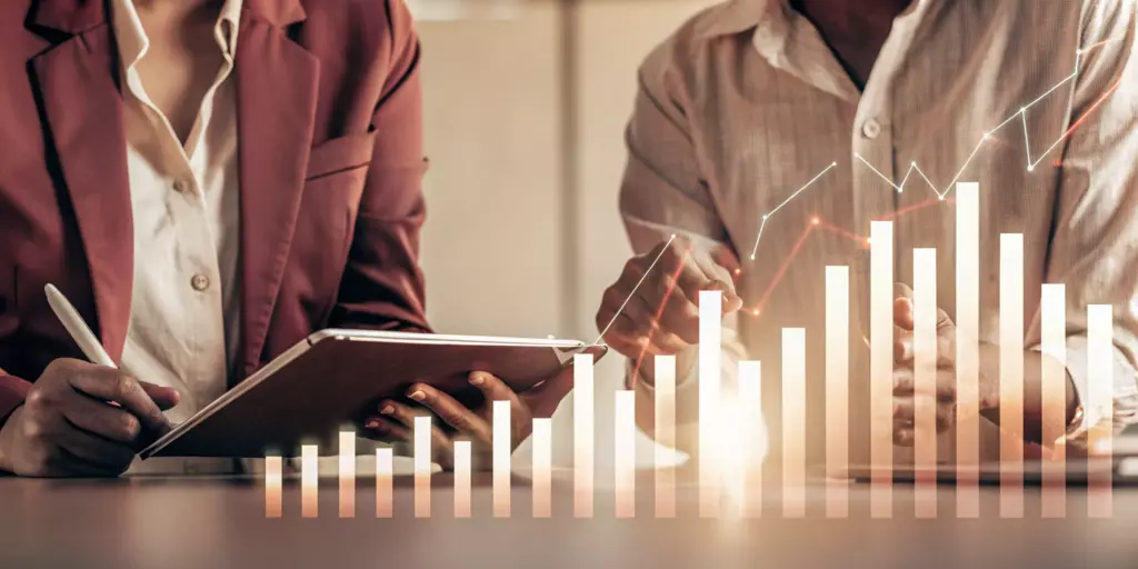 Two professionals discussing the cost of TMS for MDD with a financial bar graph.