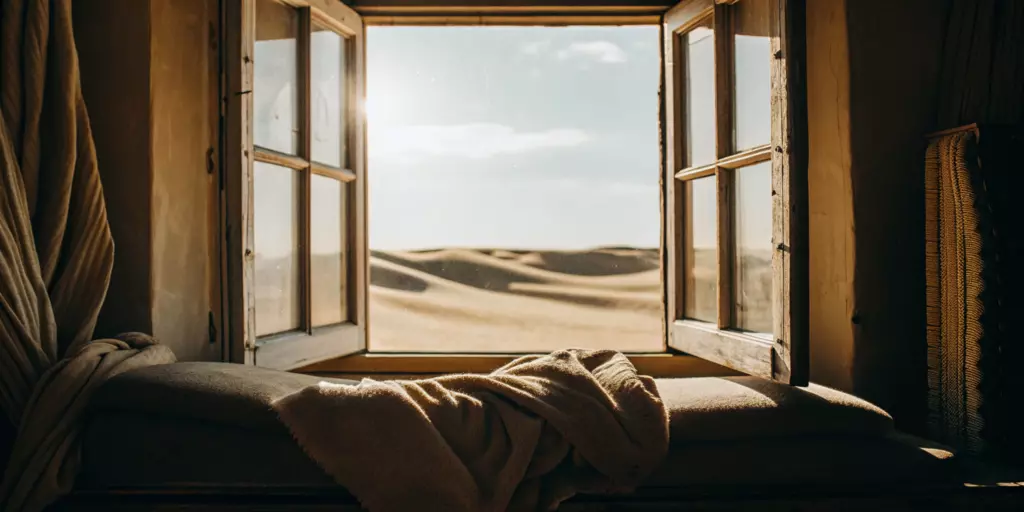 A sunlit window looking out on a peaceful desert, representing the calm relief from TMS for anxiety.