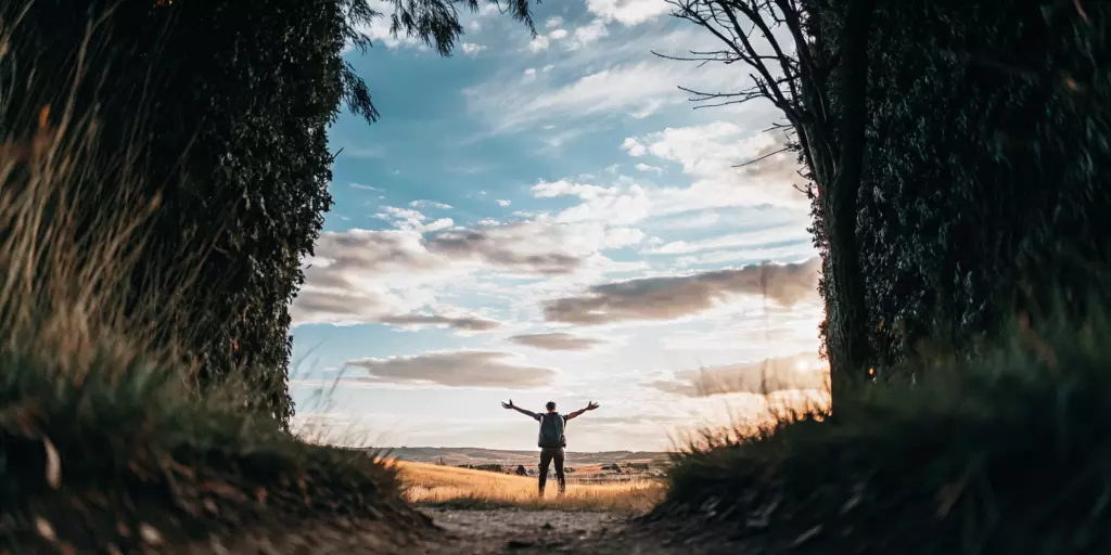 A person celebrating how TMS saved their life from anxiety in a sunlit field.