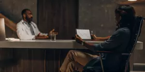 Patient and doctor reviewing progress during a TMS therapy follow-up appointment.