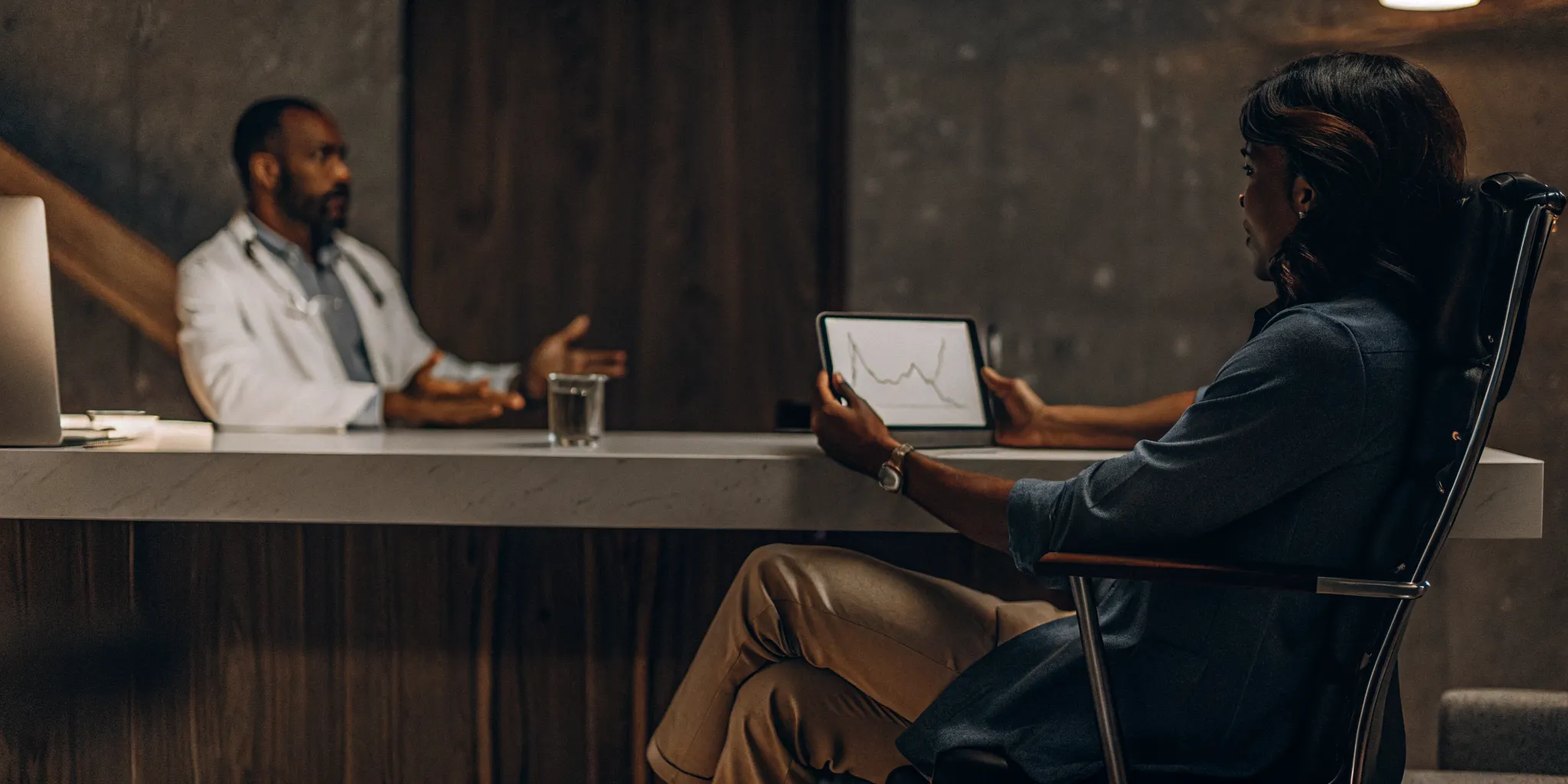 Patient and doctor reviewing progress during a TMS therapy follow-up appointment.