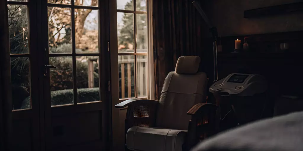 A TMS therapy machine and patient chair in a bright, comfortable treatment room.