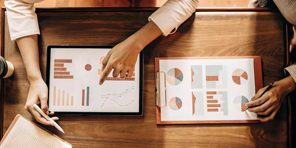 A doctor and patient making a TMS vs ECT cost comparison with a chart.