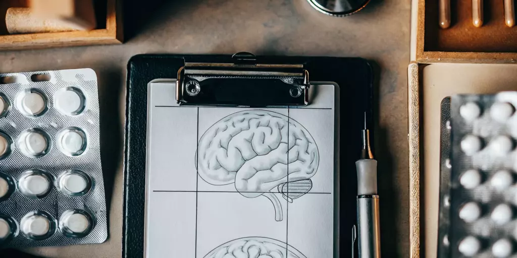 Clipboard with a brain diagram and medications for bipolar disorder management.