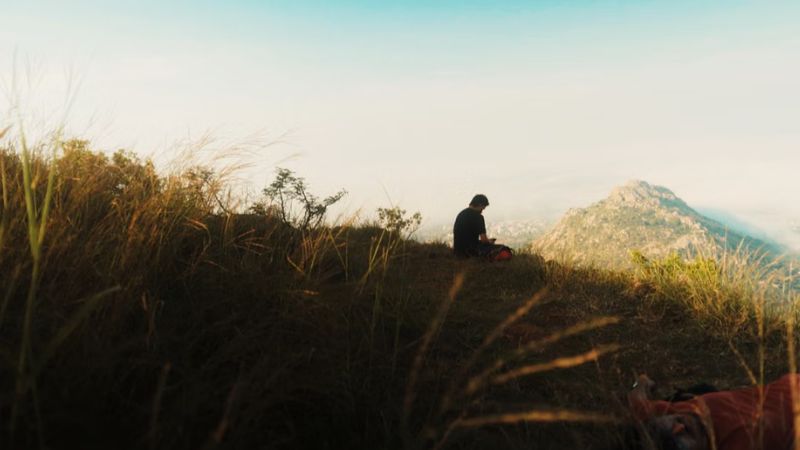 Person sitting alone on a hilltop